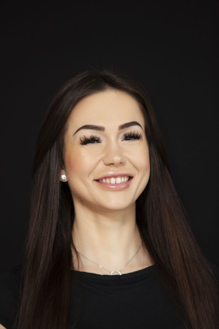 A woman with long hair smiles for the camera.