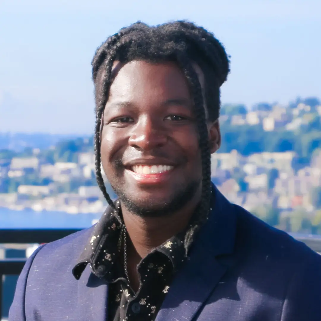 A man with long dreadlocks wearing a suit and tie.