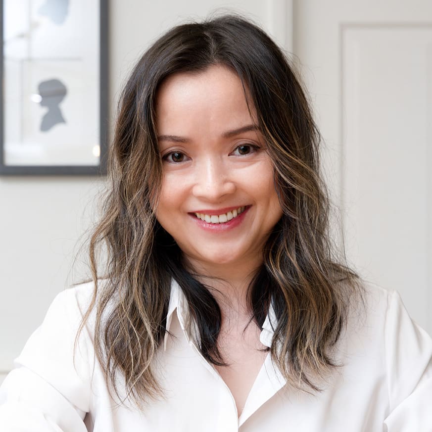 Smiling woman with wavy hair indoors.