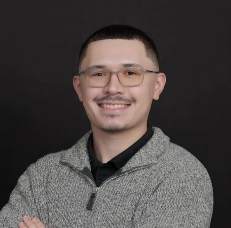 Smiling man with glasses in gray sweater